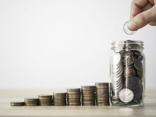 hand die munze zum speichern des glases und des stapelns von munzen legt geldsparendes investitionsgewinn und dividendenkonzept scaled