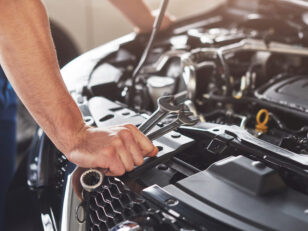 muskuloser autoservice arbeiter der fahrzeug repariert scaled