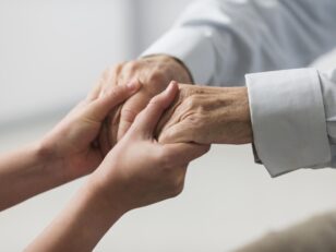 nurse holding senior man s hands sympathy scaled