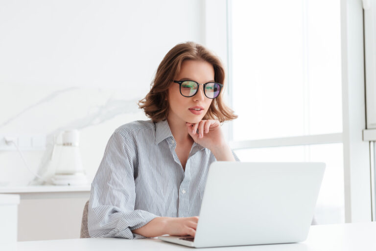 charming businesswoman glasses striped shirt working with laptop computer while siting home scaled