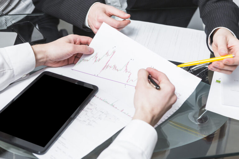 close up two businesspeople analyzing report office scaled
