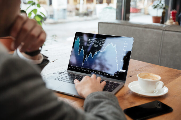 cropped image businessman sitting by table cafe analyzing indicators scaled