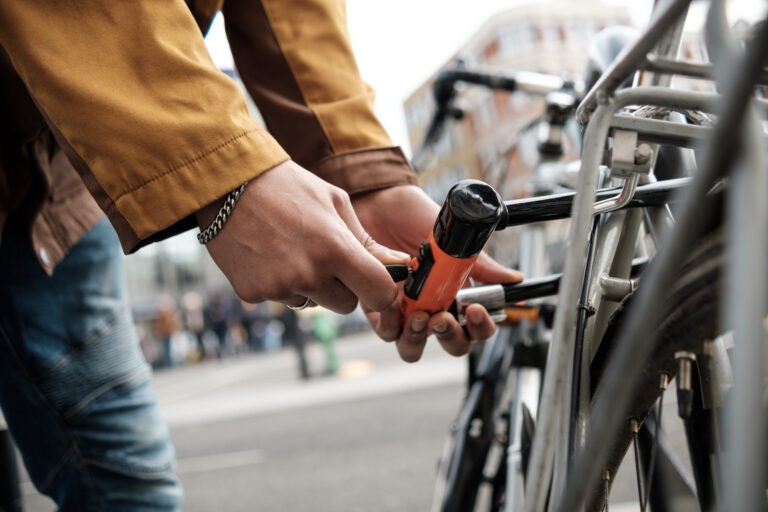 Fahrraddiebstähle: Fallzahl gesunken – Kosten gestiegen 1 cyclist securing bike with u lock on city street 2025 04 21 17 11 09 utc scaled