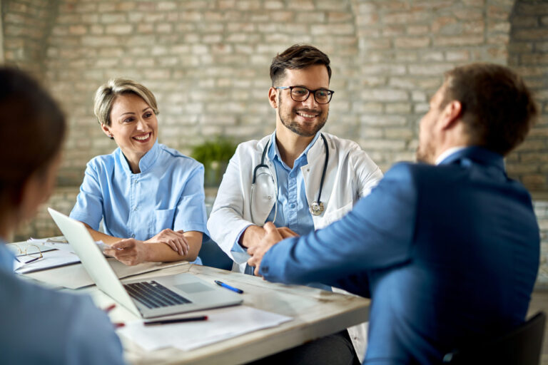 group healthcare workers greeting financial advisor meeting office focus is young doctor scaled
