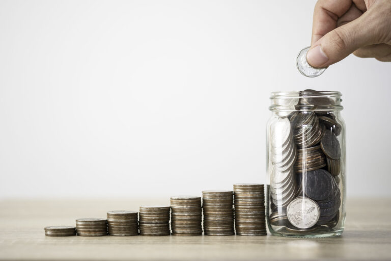 hand die munze zum speichern des glases und des stapelns von munzen legt geldsparendes investitionsgewinn und dividendenkonzept scaled