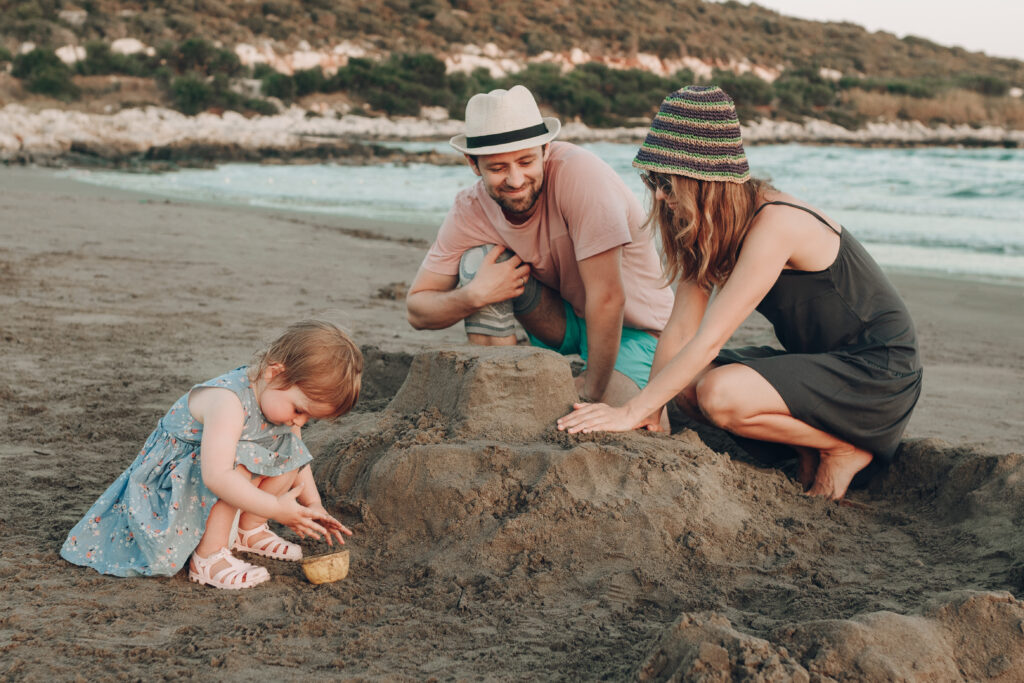 happy hipster family beach building sand castle