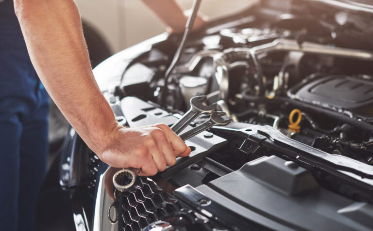 muskuloser autoservice arbeiter der fahrzeug repariert scaled